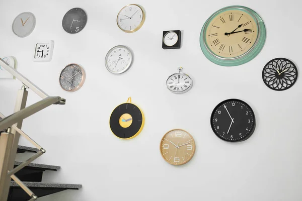 Muitos Relógios Diferentes Pendurados Parede Branca Hora Dia — Fotografia de Stock