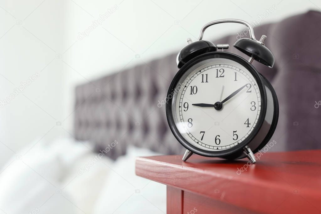 Alarm clock on bedside table. Time to wake up