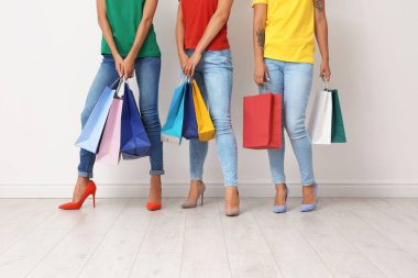 Grup alışveriş torbaları ışık duvarının yakınında olan genç kadın