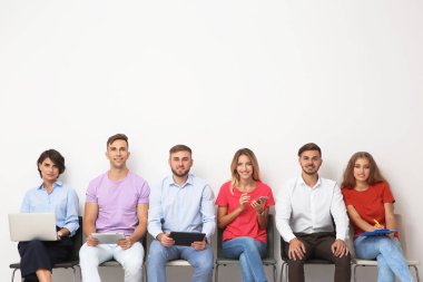 Grup Genç insan ışık duvarının yakınında iş görüşmesi için bekliyor