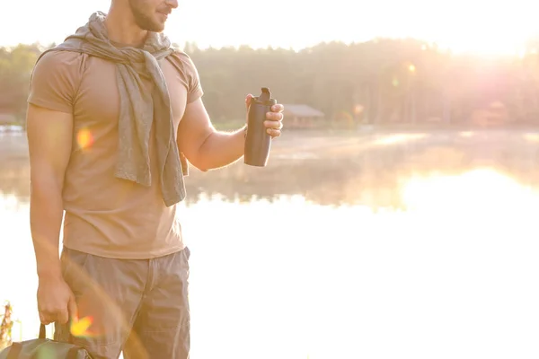 Giovane Uomo Che Beve Acqua Sulla Riva Del Bellissimo Lago — Foto Stock