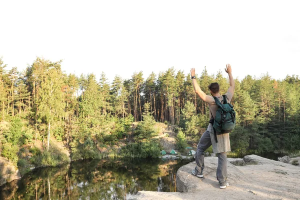 Νεαρός Άνδρας Βράχο Κοντά Στη Λίμνη Και Δάσος Κάμπινγκ Σεζόν — Φωτογραφία Αρχείου