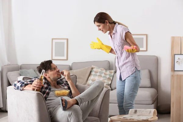 Lazy husband quarrelling with hardworking wife at home