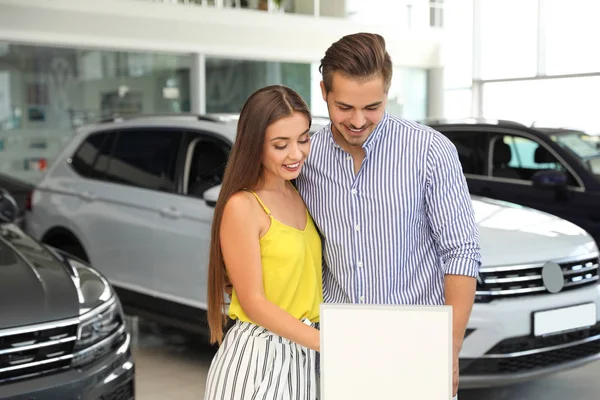 Pareja Joven Eligiendo Coche Nuevo Salón —  Fotos de Stock