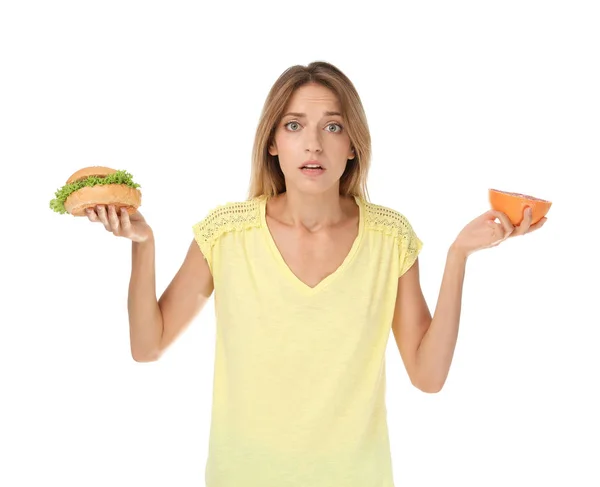 Νεαρή Γυναίκα Κρατώντας Burger Και Γκρέιπφρουτ Άσπρο Φόντο Επιλογή Μεταξύ — Φωτογραφία Αρχείου