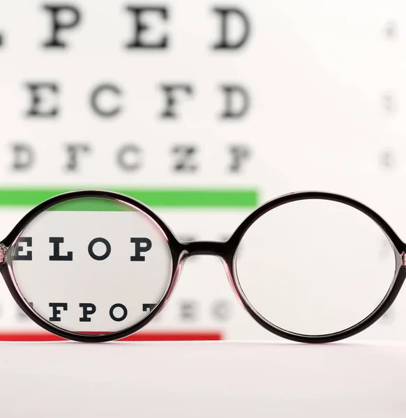 Óculos Mesa Contra Gráfico Olhos Vista Através Lentes — Fotografia de Stock