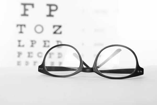 Óculos Com Lentes Corretivas Mesa Contra Gráfico Ocular — Fotografia de Stock