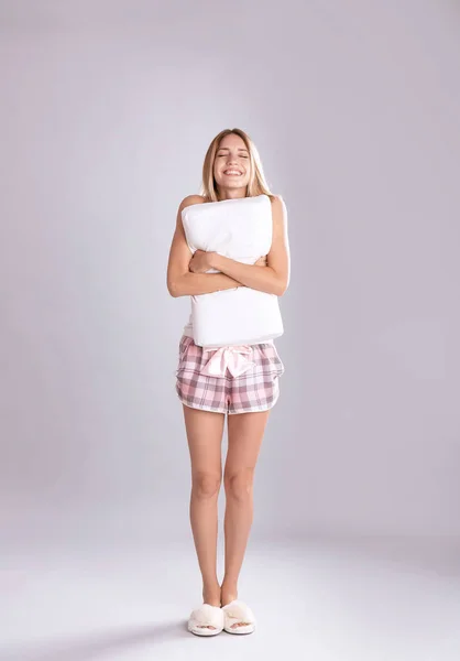 Pijama Yastık Gri Arka Plan Üzerinde Kucaklayan Genç Kadın — Stok fotoğraf