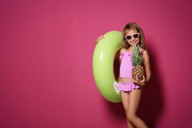 Sevimli küçük kız ile ananas ve renk arka plan üzerinde parlak şişme çalmak