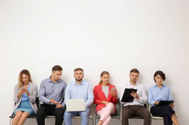 Grup Genç insan ışık duvarının yakınında iş görüşmesi için bekliyor