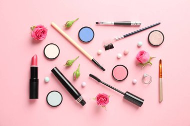 Pastel pembe arka planda dekoratif makyaj ürünleri ile düz konum
