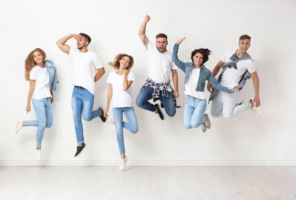 Grupo Jóvenes Jeans Saltando Cerca Pared Luz — Foto de Stock
