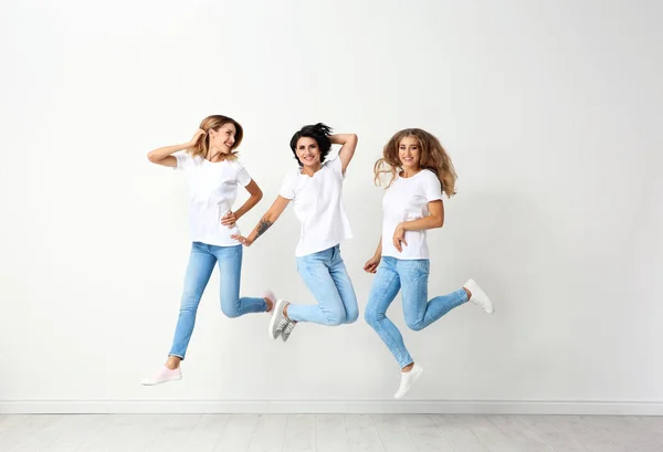 Grupo Mujeres Jóvenes Jeans Saltando Cerca Pared Luz — Foto de Stock