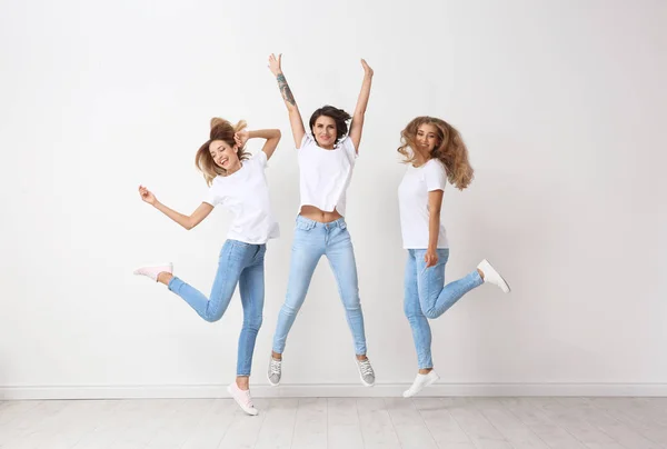 Grupo Mujeres Jóvenes Jeans Saltando Cerca Pared Luz — Foto de Stock