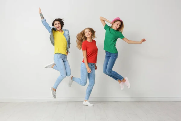 Ομάδα Νεαρών Γυναικών Τζιν Και Πολύχρωμα Μπλουζάκια Άλματα Κοντά Φως — Φωτογραφία Αρχείου
