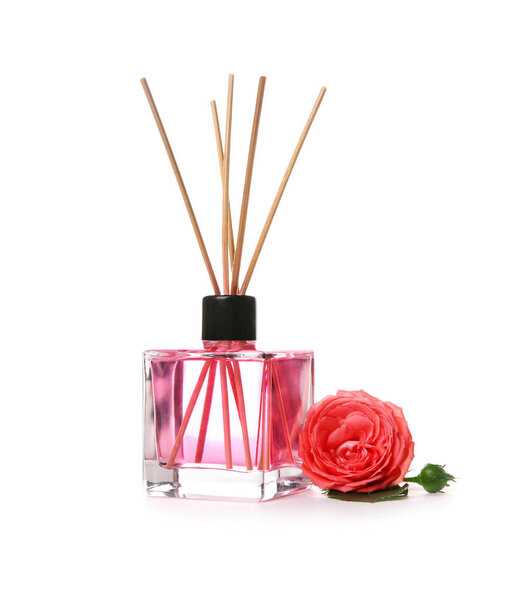 Aromatic reed air freshener and rose on white background