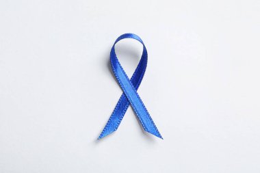 Beyaz arka plan, üstten görünüm olarak blue ribbon. Kanseri bilinçlendirme