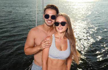 Genç adam ve onun güzel kız arkadaşı bikini yatta. Mutlu çift tatilde