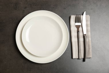 Boş dishware ve gri arka plan, üstten görünüm üzerinde çatal bıçak takımı. Tablo ayarı