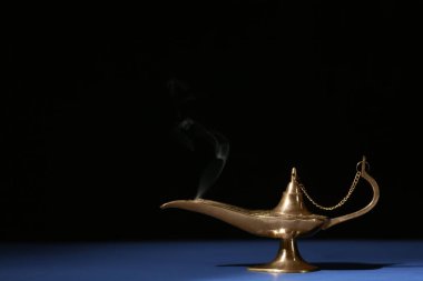 Aladdin lambayı siyah arka plan karşı masada arzuların