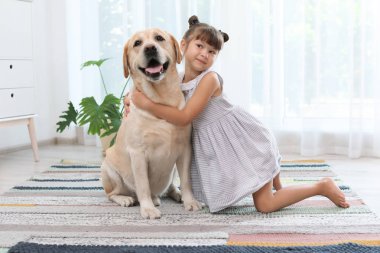 Adorable sarı labrador geri almak ve küçük kız evde