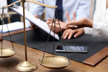 Adalet ve istemci üzerinde arka plan bulanık avukatla ölçekler