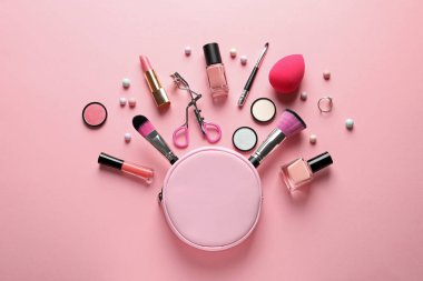 Pastel pembe arka planda dekoratif makyaj ürünleri ile düz konum