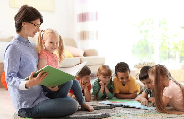 Jovem Mulher Ler Livro Para Crianças Pequenas Dentro Casa Aprendendo — Fotografia de Stock