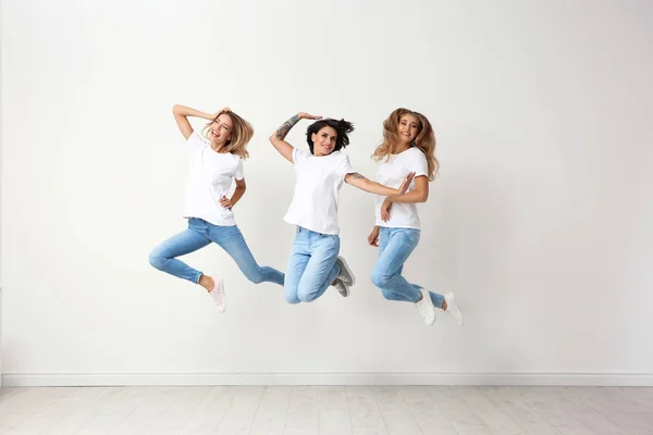 Grupo Mujeres Jóvenes Jeans Saltando Cerca Pared Luz — Foto de Stock