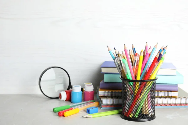Different school stationery on table against light background