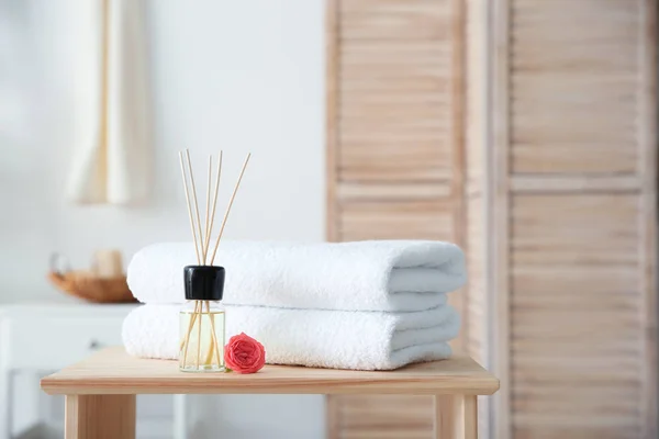 Schilfrohr Lufterfrischer Und Ein Stapel Handtücher Auf Dem Tisch Vor — Stockfoto