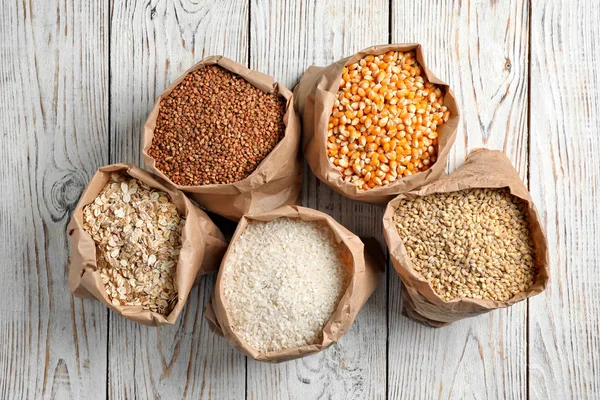 Bolsas Diferentes Granos Cereales Sobre Fondo Madera Vista Superior —  Fotos de Stock