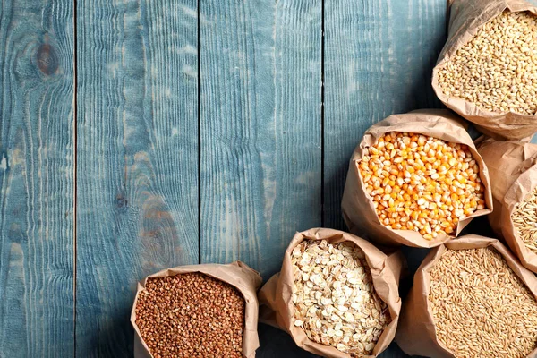 Bolsas Diferentes Granos Cereales Sobre Fondo Madera Composición Plana Con —  Fotos de Stock