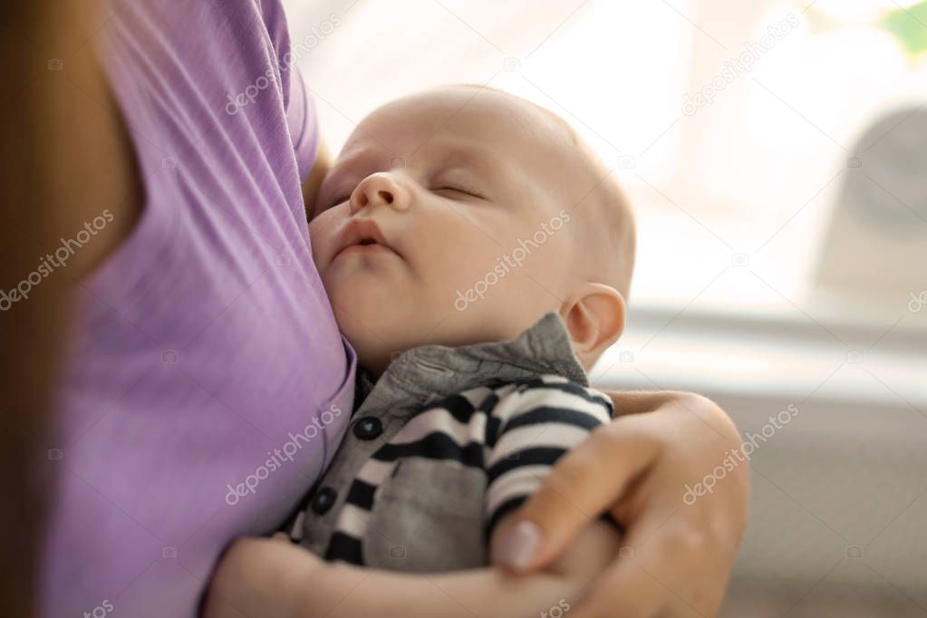 Mother with her sleeping baby at home, closeup view