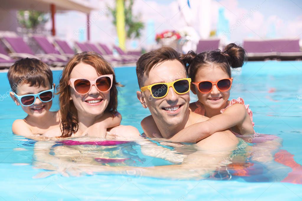 Happy family in swimming pool at resort