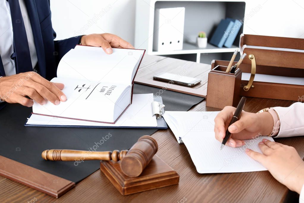 Male lawyer working with client at table in office