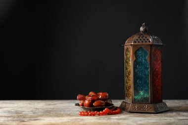 Müslüman lamba, tarihler ve tesbih ahşap masa üzerinde. Ramazan sembolü olarak Fanous