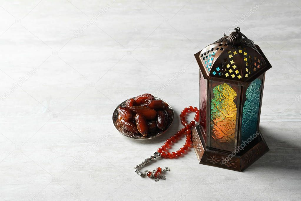 Muslim lamp, dates and misbaha on light background. Fanous as Ramadan symbol