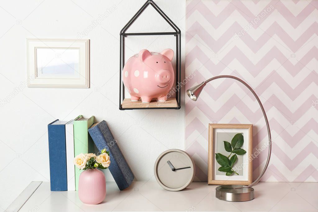 Cute piggy bank on shelf indoors. Stylish interior element
