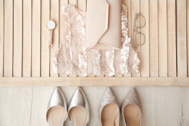 Ahşap arka plan üzerinde kadın için şık kıyafeti ile düz yatıyordu kompozisyon