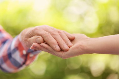 Yaşlı adam el bulanık arka planda, closeup tutan genç kadın. Yardım hizmeti