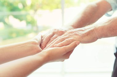 Bulanık arka planda ellere yardım etmek, yakın çekim. Yaşlılara bakım kavramı