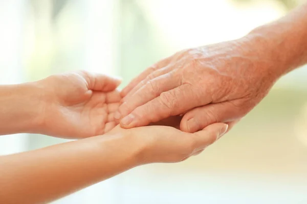 Young Woman Holding Elderly Man Hand Blurred Background Closeup Help — Stock Photo, Image