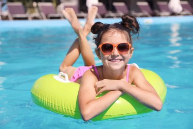 Yüzme havuzunda şişme halka ile küçük kız