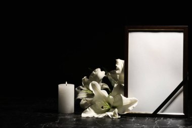Funeral photo frame, burning candle and lily flowers on dark background clipart