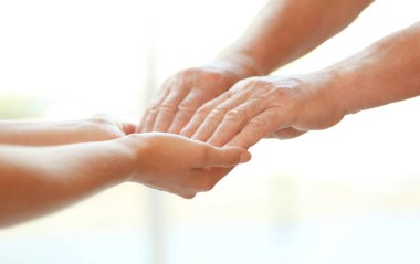 Bulanık arka planda, closeup eller genç kadın yaşlı adam tutarak. Yardım hizmeti