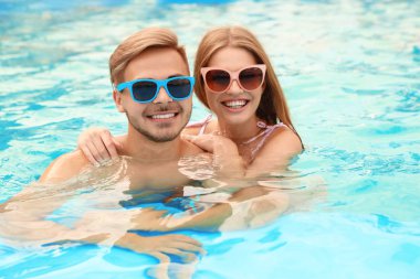 Güneşli havuzunda genç çift