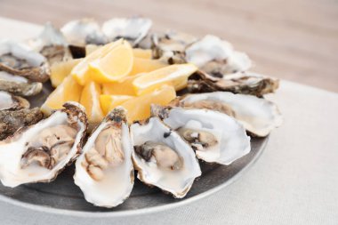 Plaka, closeup üzerinde kesme sulu limonlu taze istiridye