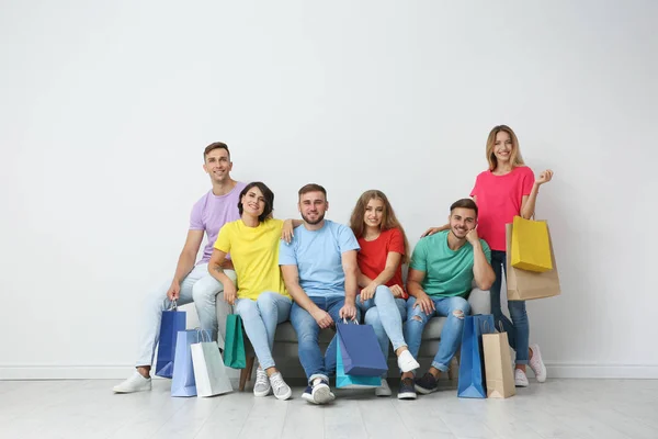 Group Young People Shopping Bags Sitting Sofa Light Wall — Stock Photo, Image