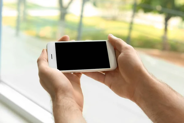 Mann Hält Handy Mit Leerem Bildschirm Auf Verschwommenem Hintergrund Nahaufnahme — Stockfoto